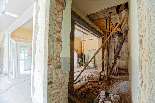 An Image Of A Room With Asbestos Drywall Under Construction With A Worker On A Ladder